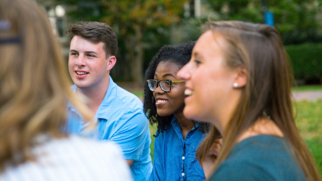 Georgetown University undergraduate students seated talking on the quad