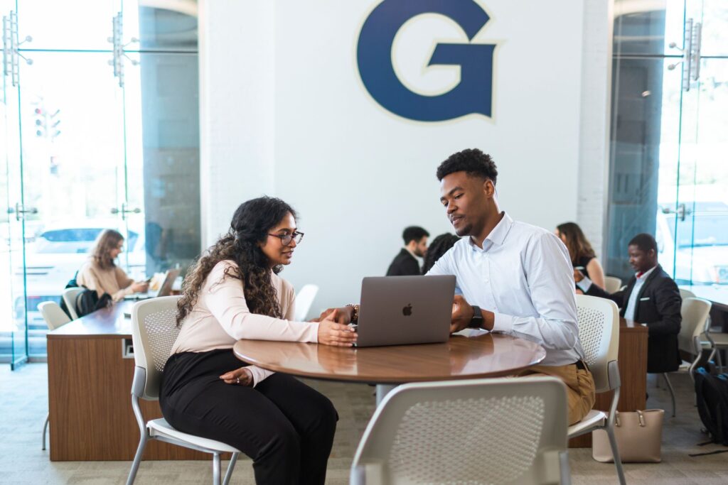 students talking at a table and studying
