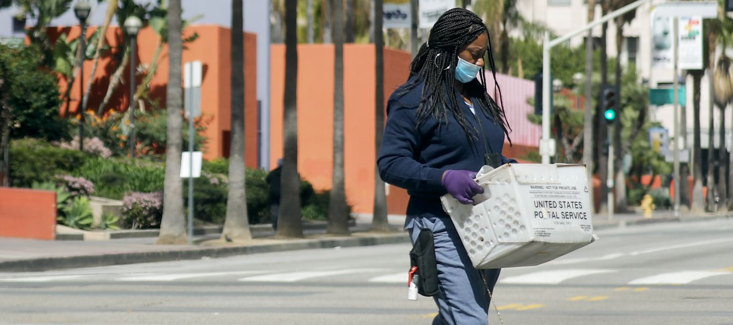 Frontline worker holding United States Postal Service box