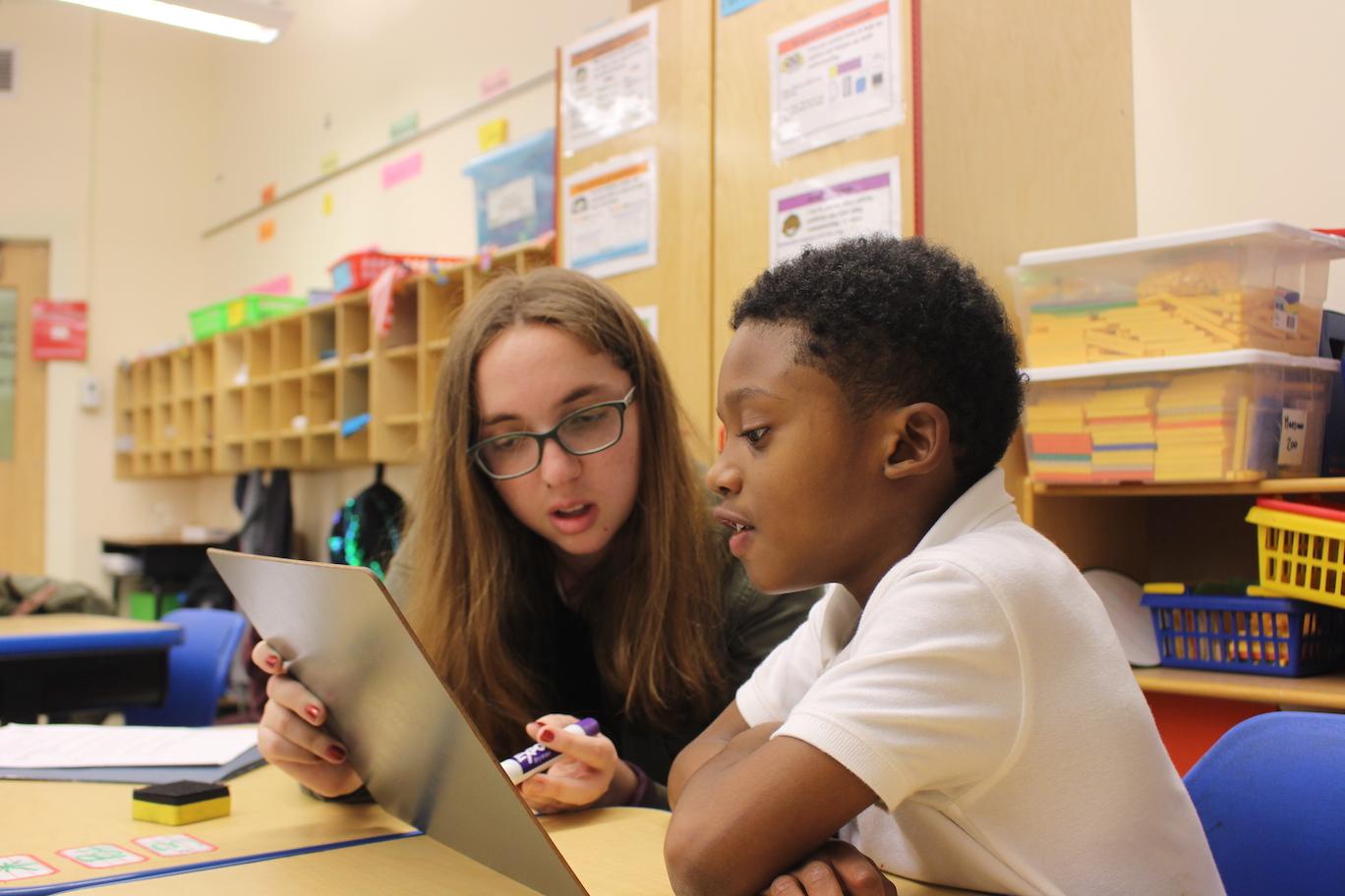 Malik is being tutored by Christina, a tutor in the DC Reads program, at Neval Thomas Elementary