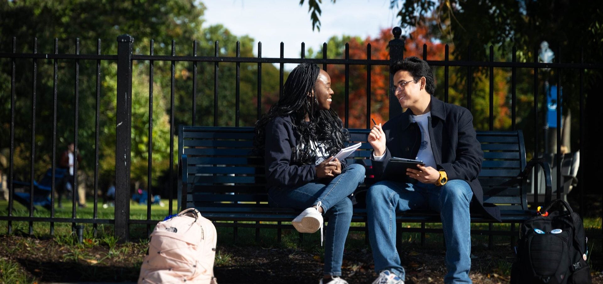 students sitting on a bench, talking