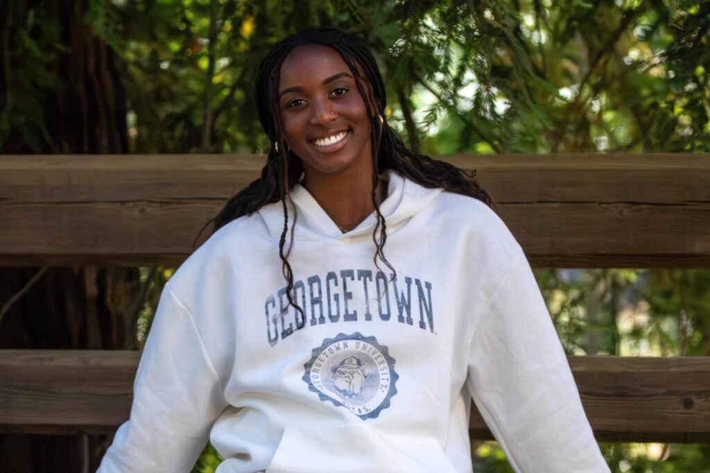 Headshot of Amara Aimufua in a white Georgetown sweatshirt