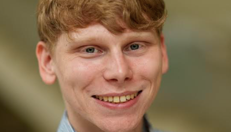 Headshot of Zachary Vossler in a blue collared shirt