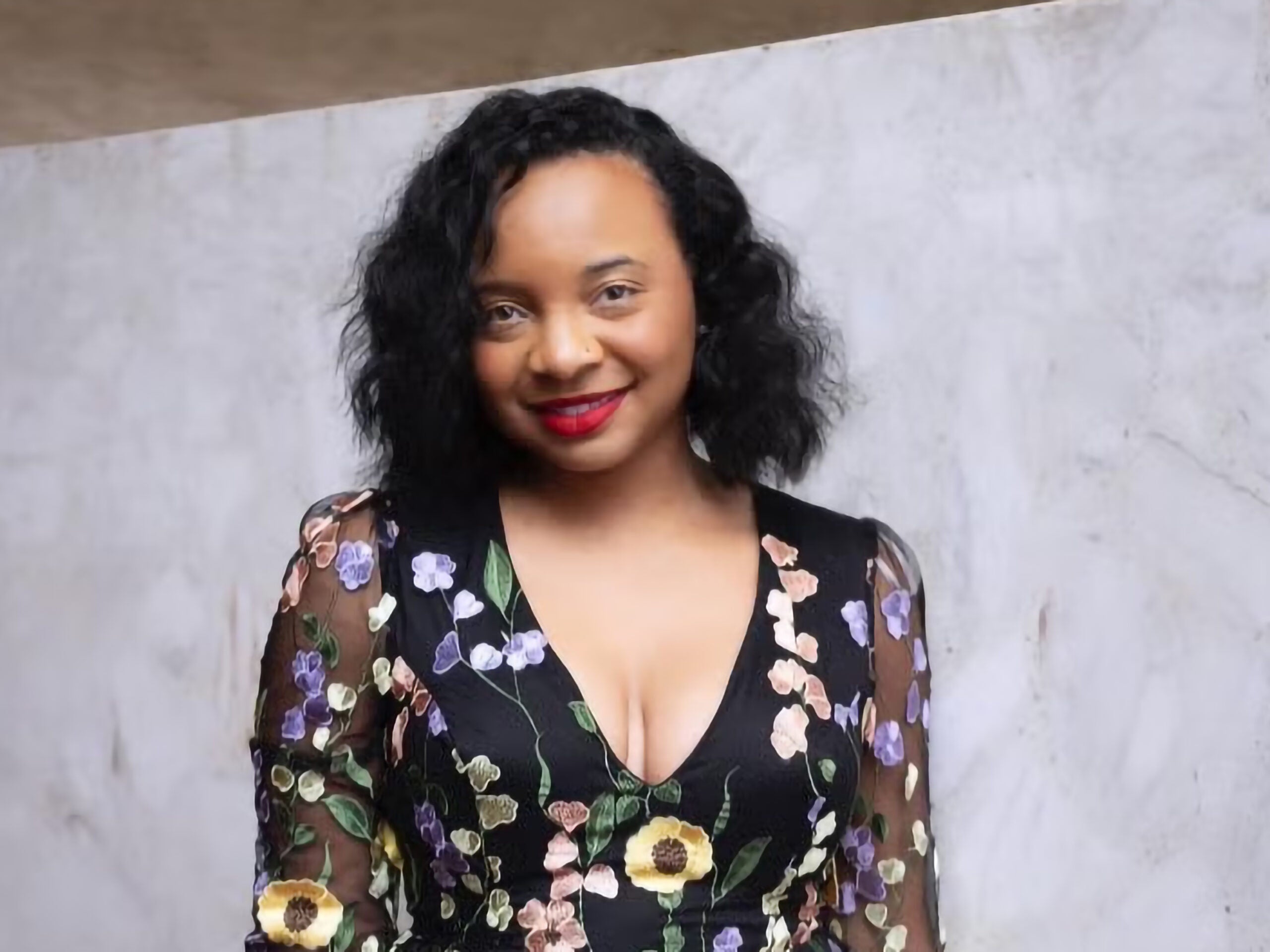 Chanel Williams wearing a floral dress and smiling.